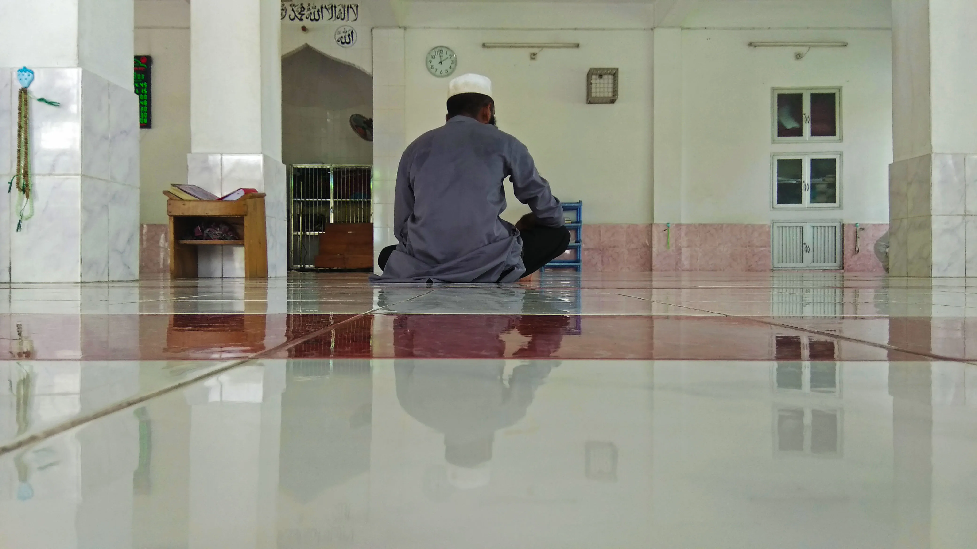 Seorang pria membaca Alquran di dalam masjid