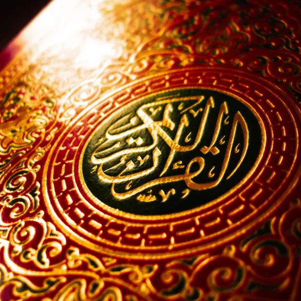 Sampul Al-Qur’an berornamen emas dalam cahaya hangat